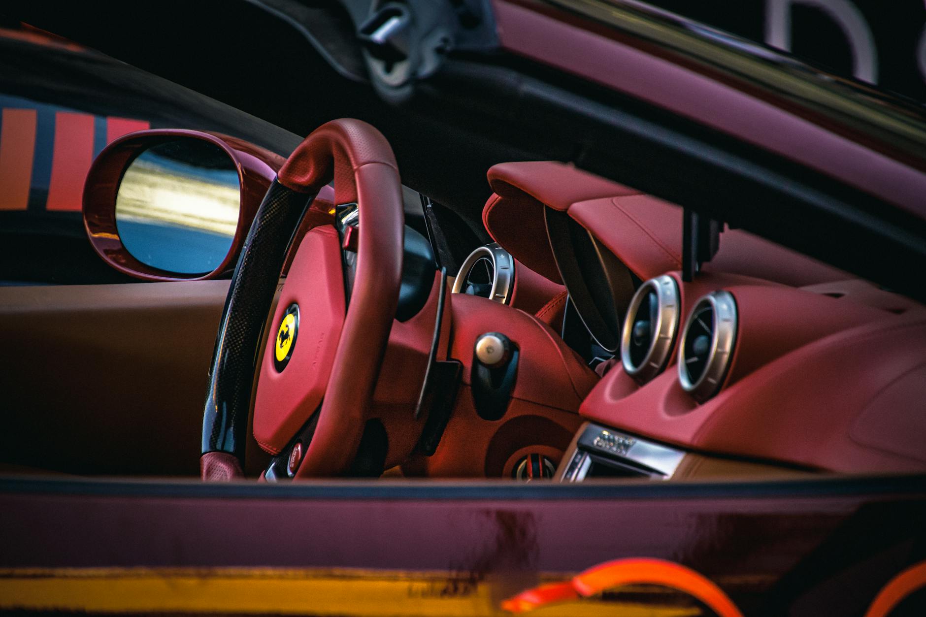Wnętrze Lamborghini z czerwonymi, skórzanymi fotelami i kierownicą