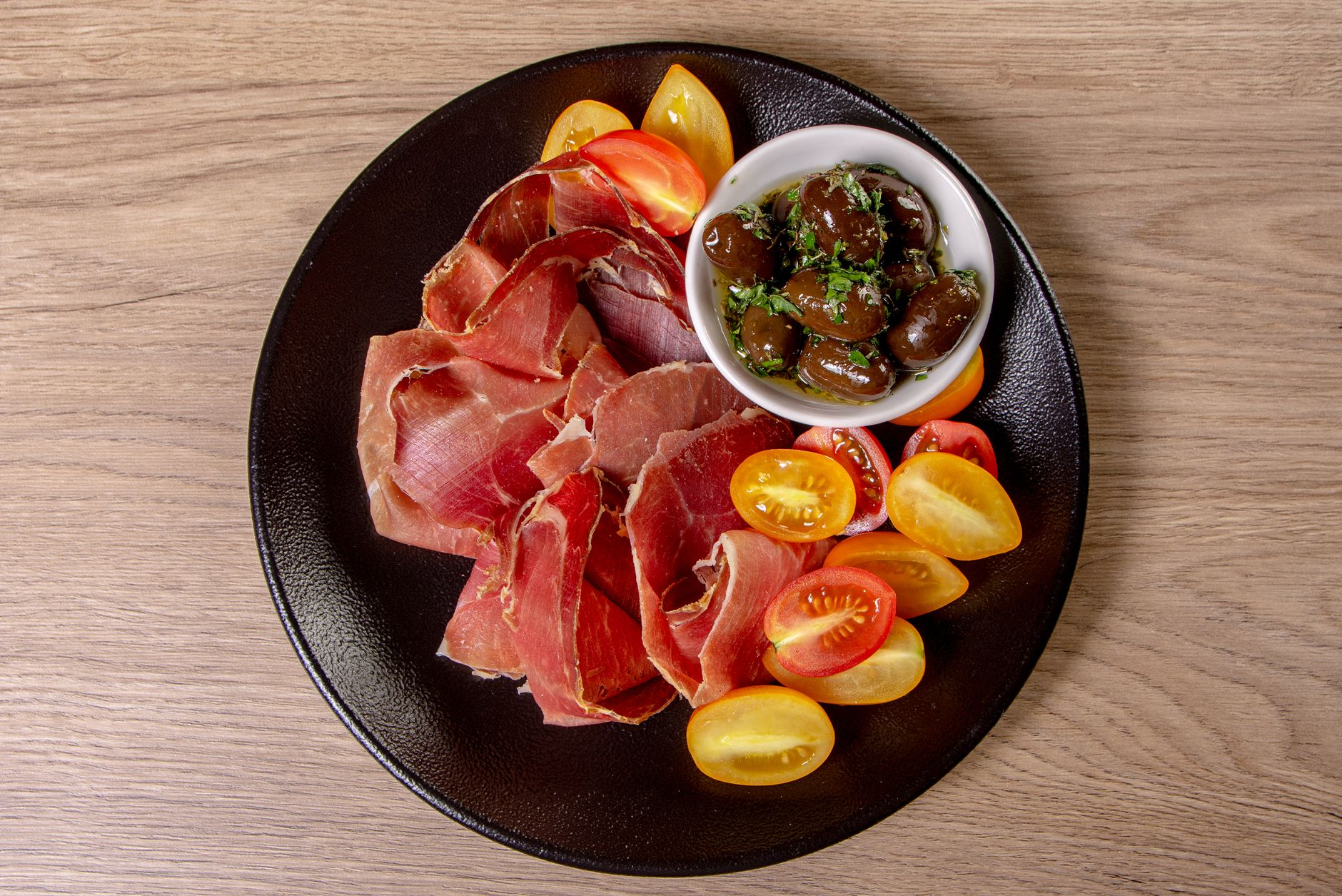 Deska tapas z dojrzewającą szynką, pomidorkami koktajlowymi i oliwkami