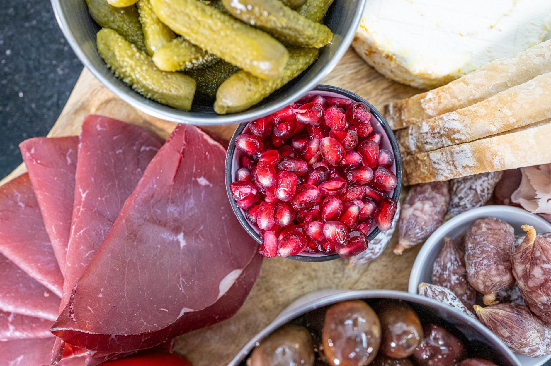 Deska tapas z szynką dojrzewającą, ogórkami, pestkami granatu i pieczywem