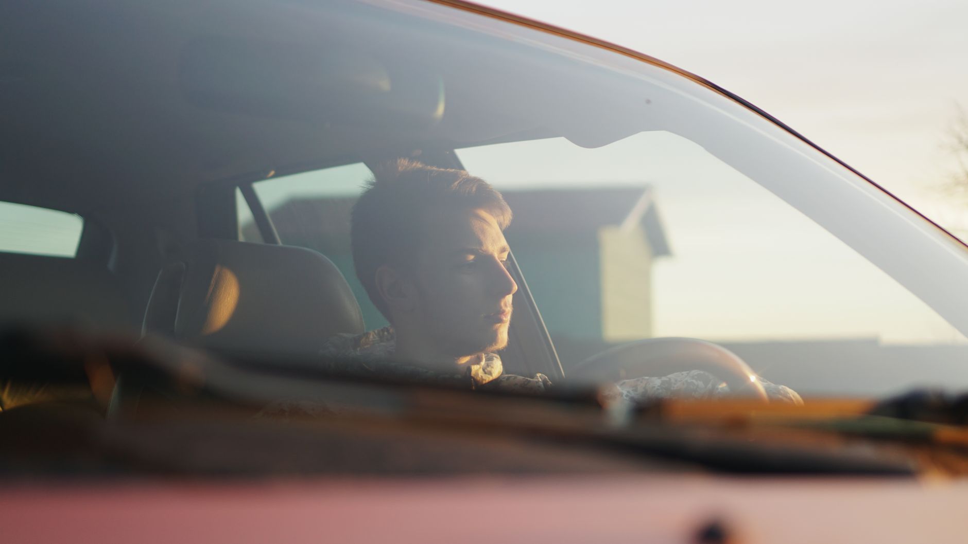 Mężczyzna prowadzi Renault w słońcu wpadającym przez przednią szybę