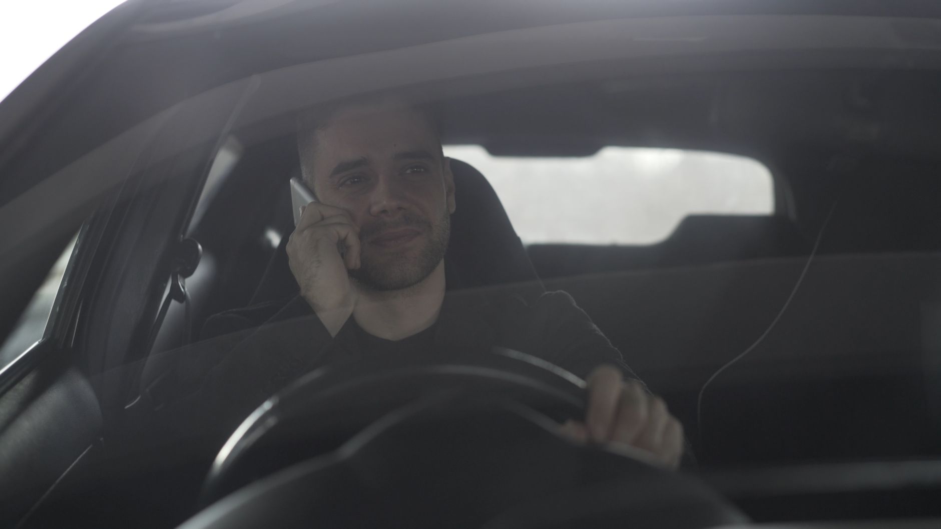 Kierowca Volkswagena rozmawia przez telefon za kierownicą